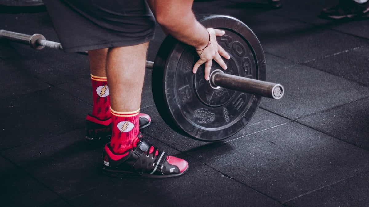 person arranging barbell plate